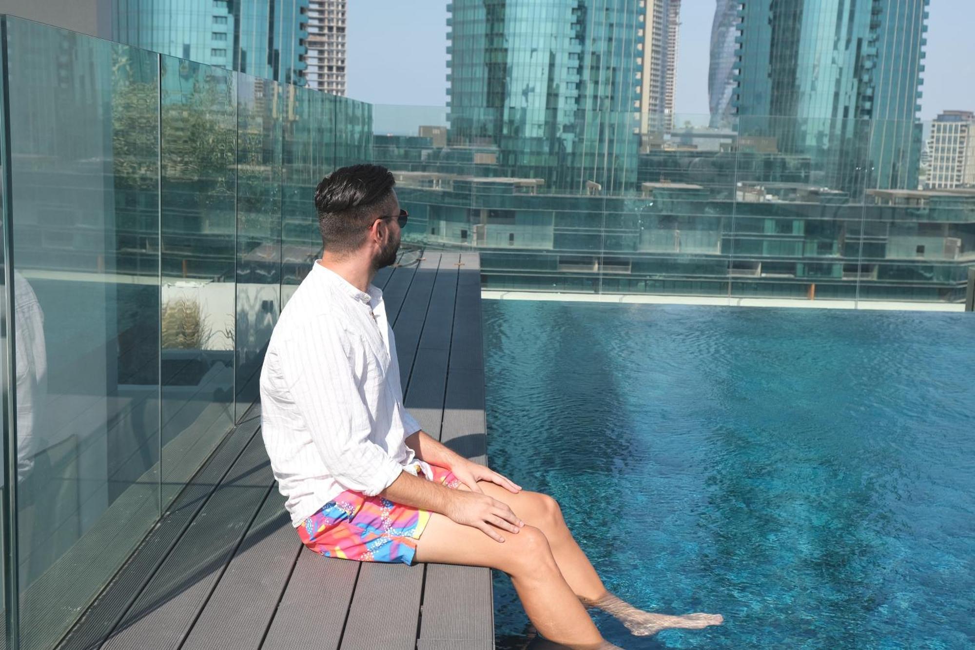 Отель Charthouse Bahrain Манама Экстерьер фото A man sitting on the edge of a pool